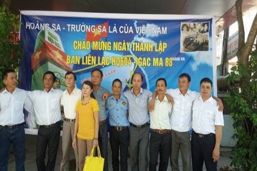 Chị Trần Thị Liễu, vợ liệt sĩ Gạc Ma Nguyễn Mậu Phong, chụp ảnh với các cựu binh Gạc Ma - Ảnh: Hồ Văn