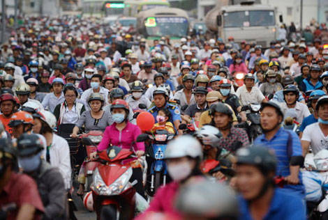 Với nhiều người nghèo, việc thu phí xe máy là một gánh nặng. Trong ảnh: người dân chen chúc đi xe qua cầu Chà Và, Q.8, TP HCM - Ảnh: Thuận Thắng.