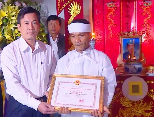 Ông Cao Thanh Thương, Chủ tịch UBND huyện Hoài Nhơn tặng giấy khen cho thân nhân gia đình vì anh Quang đã có thành tích dũng cảm trong thực hiện nhiệm vụ khắc phục hậu quả lũ lụt dẫn đến tử vong.