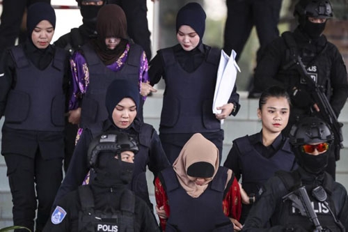 Đoàn Thị Hương (áo tím) và Siti Aisyah (áo đỏ) bị cảnh sát áp giải tới tòa thượng thẩm Shah Alam ở Malaysia hôm 14/12. Ảnh: AFP.