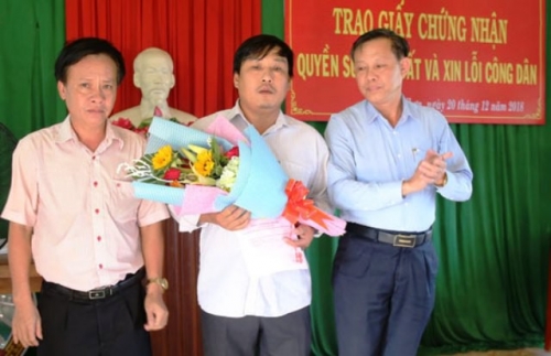 Đại diện lãnh đạo huyện Hoài Nhơn gặp mặt công dân xin lỗi và trao giấy chứng nhận quyền sử dụng đất (ảnh: Báo Bình Định).