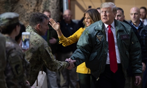 Trump (cà vạt đỏ) thăm căn cứ tại Iraq. Ảnh: AFP.