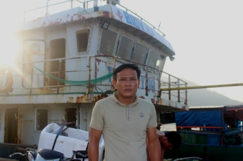 Ngư dân Trần Xuân Sinh bên chiếc tàu đóng theo Nghị định 67 của Chính phủ. Ảnh: Thùy Trang