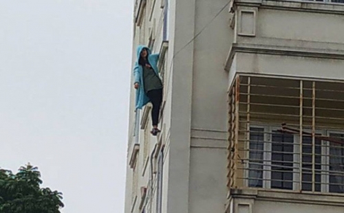 Hình ảnh cô gái đung đưa bên ngoài cửa sổ tầng 4 chung cư - Ảnh: Facebook
