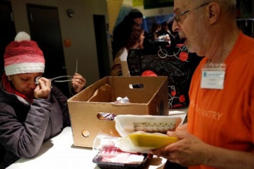 Một nhân viên chính phủ xếp hàng nhận cơm từ thiện do không được trả lương trong gần 1 tháng qua (Ảnh: Reuters)