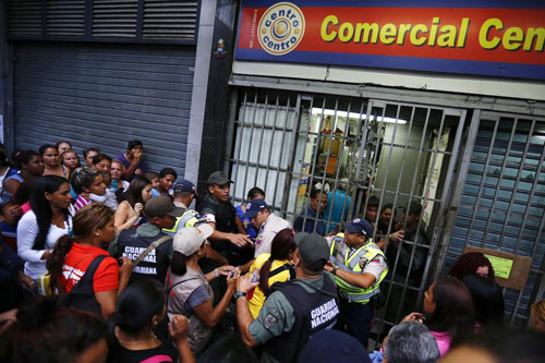 Dân Venezuela chen lấn bên ngoài một điểm phân phối lương thực. Ảnh: AFP.
