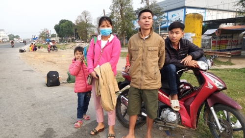 Gia đình chị Hoàng Thị Lan đứng tại đầu đường tránh thành phố Hà Tĩnh để đón xe ra Hà Nam nhưng các xe đã kín chỗ ẢNH PHẠM ĐỨC
