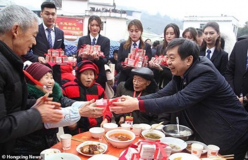 Ông Zheng trao tiền mừng tuổi cho dân làng (Ảnh: Hongxing News)