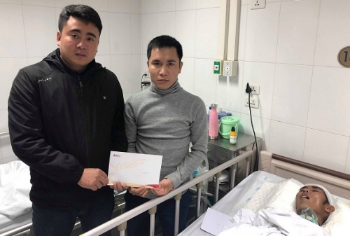 Đại diện báo VietNamNet (bên trái) trao tiền bạn đọc ủng hộ em Trịnh