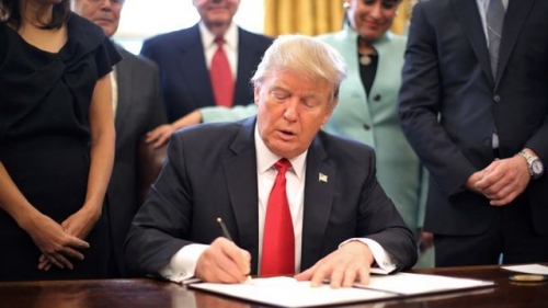 Tổng thống Donald Trump ký một sắc lệnh hành pháp tại Nhà Trắng. (Ảnh: Reuters)