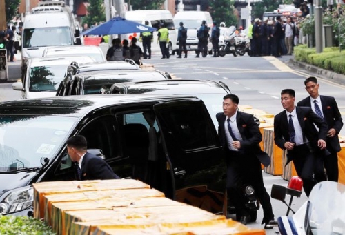 12 vệ sĩ mặc vest đen chạy bộ theo xe ô tô chở ông Kim Jong-un tại khách sạn St Regis khi nhà lãnh đạo Triều Tiên đặt chân tới Singapore hôm nay 10/6. (Ảnh: Reuters)