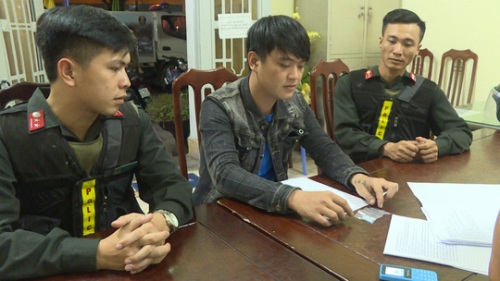 Huỳnh Thanh Duy (ngồi giữa) tại cơ quan công an