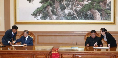 Bà Kim đưa bút cho anh trai ký vào thỏa thuận với Hàn Quốc tháng 9 năm ngoái (Ảnh: Reuters)