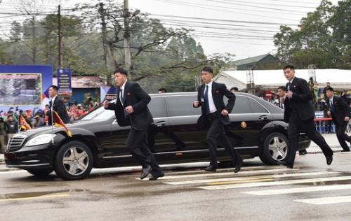 Nhóm vệ sĩ chạy theo xe chở ông Kim Jong-un một đoạn rồi lên đoàn xe hộ tống về Hà Nội. Ảnh: Reuters